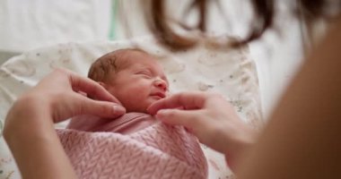 Yumuşak bir el tarafından nazikçe kucaklanırken gülümseyen, rahat bir battaniyeye sarılmış yeni doğmuş şirin bir bebek. Yeni doğmuş bir bebek bir hastane beşiğinde rahatça sarılıp yatar Saf Masumiyet ve Neşe saçar