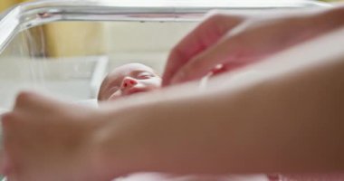 Yeni doğmuş bir bebeğin yeni hayatın masumiyetini ve saflığını simgeleyen sıcak bir beşikte dinlendiği huzurlu bir an. Son Rahatlık ve Bakım İçin Yumuşak ve Sıcak Bir Battaniyeye Sarılmış Yeni Doğmuş Bir Bebek