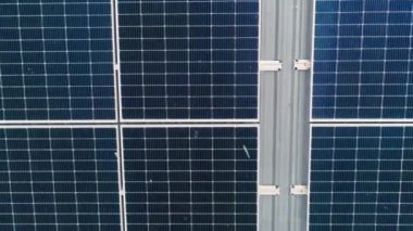 Mavi fotovoltaik güneş panellerinin yüzeyi, temiz ekolojik elektrik üretmek için çatıya monte edildi. Yenilenebilir enerji konsepti üretimi. Güneş panellerinin İHA Hava Görüntüsü.