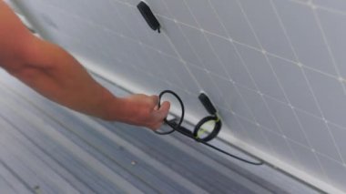 Güneş teknisyenleri çatıya güneş panelleri kuruyor. Ekolojik Yenilenebilir Enerji Konsepti. Teknisyenler parlak güneş ışığı altında evin çatısına PV güneş panelleri kuruyorlar. Yavaş çekim