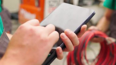 Elektrik işçisi, dijital tabletle çalışıyor. Kuleye yakın bir yerde elektrik var. Enerji sektörü teknoloji endüstrisi konsepti. Elektrik mühendisi tablet üzerinde çalışıyor.