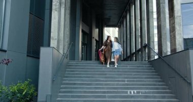 Farklı etnik kökenlere sahip iki yetişkin kadın bir köpekle birlikte modern şehir merdivenlerinde geziniyor, arkadaşlık ve kentsel yaşam tarzlarını aktarıyorlar. Kızı ve annesi birlikte vakit geçiriyorlar..