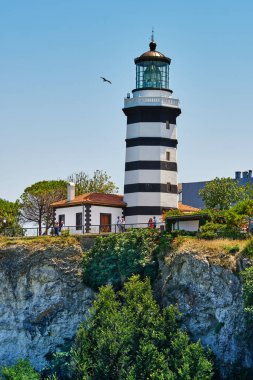 Istanbul, Turkey - July 20, 2022, Sile, The main attraction of the city is an old lighthouse on the Black Sea, tourists walk near the lighthouse. Seascape