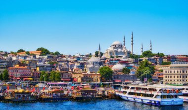 Istanbul, Turkey. July 23, 2019. View of the Suleymaniye Mosque, Eminonu pier and the Golden Horn. People on the pier. Passenger boats carry people
