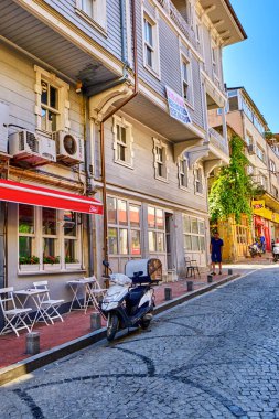 Istanbul, Turkey, July 18, 2022. Beautiful and colorful old buildings in the Arnavutkoy region on the embankment of Bosphorus. People walk the streets