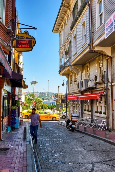 Istanbul, Turkey, July 18, 2022. Beautiful and colorful old buildings in the Arnavutkoy region on the embankment of Bosphorus. People walk the streets
