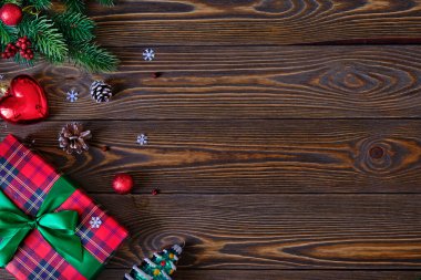 Noel kompozisyonu. Noel ağacı dalları ve kırmızı hediye kutusu eski ahşap masada yakın plan.