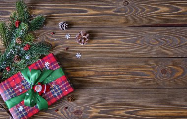 Noel kompozisyonu. Noel ağacı dalları ve kırmızı hediye kutusu eski ahşap masada yakın plan.