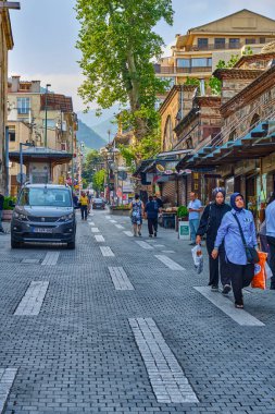 Bursa, Türkiye, 20 Temmuz 2024, Cami Ulu-Jami ve eski evleri, dükkanları ve kafeleri olan sokaklar. Eski şehrin sokaklarında insanlar yürüyor.