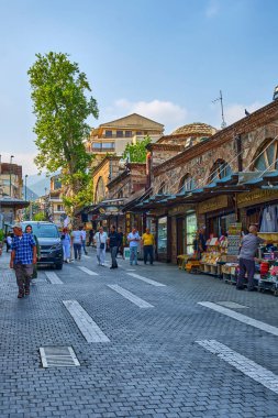 Bursa, Türkiye, 20 Temmuz 2024, Cami Ulu-Jami ve eski evleri, dükkanları ve kafeleri olan sokaklar. Eski şehrin sokaklarında insanlar yürüyor.