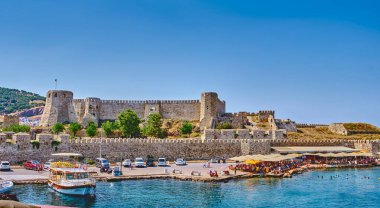 Bozcaada, Türkiye, 18 Temmuz 2024, marina manzarası, plajlar ve adanın başlıca eğlence alanlarından biri olan Bozcaada kalesi. Turistler sahilde dinlenir.