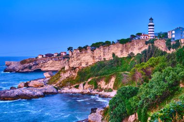 Sile, Türkiye, Deniz feneri Karadeniz 'in kayalık kıyılarında gün batımından sonraki akşam mavi gökyüzüne karşı. Şehrin popüler tarihi yeri.