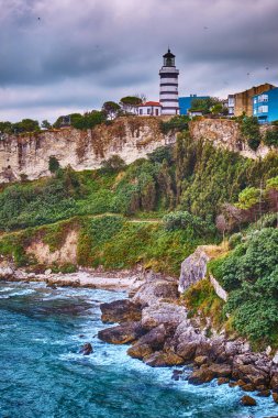 Karadeniz 'in kayalık kıyılarındaki Sile, Türkiye, Deniz feneri bulutlu bir gökyüzünün arka planına karşı. Şehrin popüler tarihi yeri.