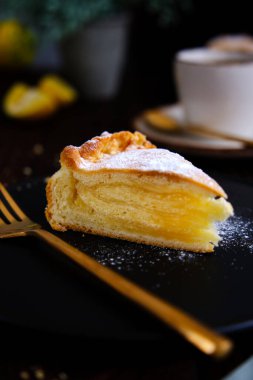 Siyah tabakta limonlu turta ve eski ahşap bir masada aromatik kahve.