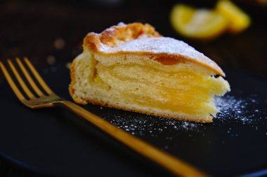 Siyah tabakta limonlu turta ve eski ahşap bir masada aromatik kahve.