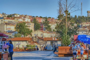 Sile, Türkiye, 8 Temmuz 2025, güzel evleri ve parlak çiçekleri olan renkli sokaklar. Şehrin ana meydanı. Meydanda yürüyen insanlar