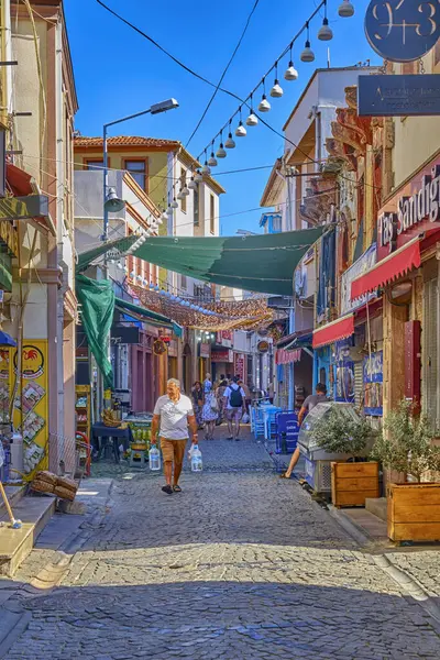 Ayvalik, Türkiye, 13 Temmuz 2025, Renkli evleri, kafeleri ve dükkanları olan kentin merkezindeki sokaklar, insanlar sokaklarda yürüyor