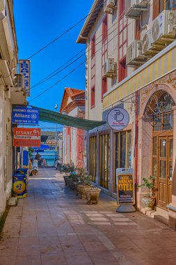 Ayvalik, Türkiye, 13 Temmuz 2025, Renkli evleri, kafeleri ve dükkanları olan kentin merkezindeki sokaklar, insanlar sokaklarda yürüyor