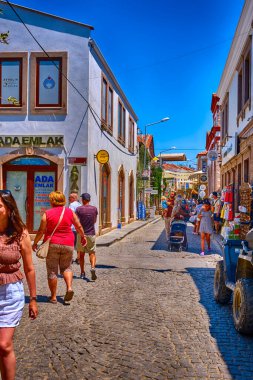 Ayvalik, Türkiye, 14 Temmuz 2025, Cunda Adası, renkli evleri, kafeleri ve dükkanları olan sokaklar, turistler sokaklarda yürüyor