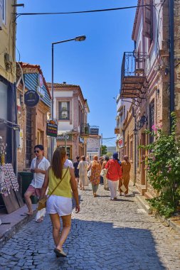 Ayvalik, Türkiye, 14 Temmuz 2025, Cunda Adası, renkli evleri, kafeleri ve dükkanları olan sokaklar, turistler sokaklarda yürüyor