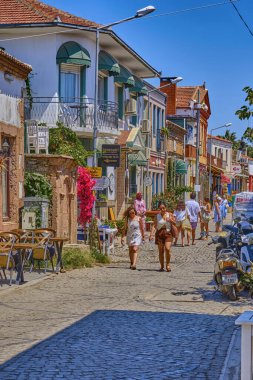 Ayvalik, Türkiye, 14 Temmuz 2025, Cunda Adası, renkli evleri, kafeleri ve dükkanları olan sokaklar, turistler sokaklarda yürüyor