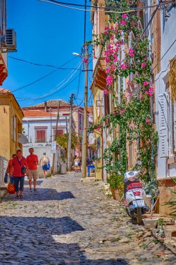 Ayvalik, Türkiye, 14 Temmuz 2025, Cunda Adası, renkli evleri, kafeleri ve dükkanları olan sokaklar, turistler sokaklarda yürüyor