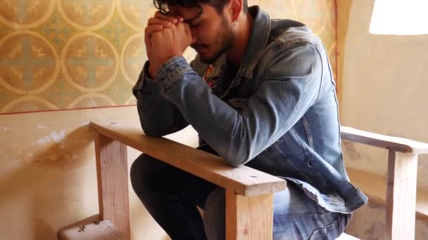 Młody Człowiek Siedzący Klęczący Kościele Modląc Się Drewnianej Ławce — Wideo stockowe