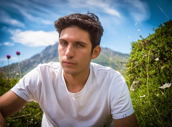 Yakışıklı Genç Adam Yemyeşil Dağ Manzarasında Yürüyüş Yaparken Kameraya Bakıyor — Stok fotoğraf