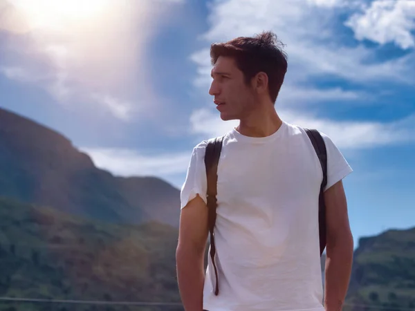 緑豊かな山の風景の中にバックパックでハンサムな若い男のハイキングを離れて見て — ストック写真