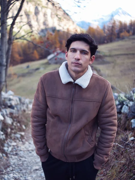 秋や冬には山の中で魅力的な若い男は スエードのジャケットを着て カメラを見て — ストック写真