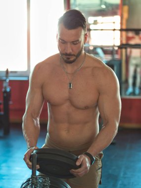 spor salonunda egzersiz sırasında kas gövde, pecs ve abs gösterilen istirahat kaslı, üstsüz erkek vücut geliştirmeci