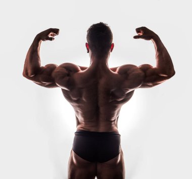 İç çamaşırı giyen, klasik vücut geliştirme pozu veren yakışıklı atletik bir gencin dörtte üçü.