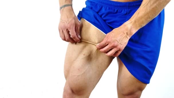 体形匀称 体格健壮 肌肉发达的男人捏着腿皮 露出大腿肌肉 以检查他的脂肪百分比 — 图库视频影像