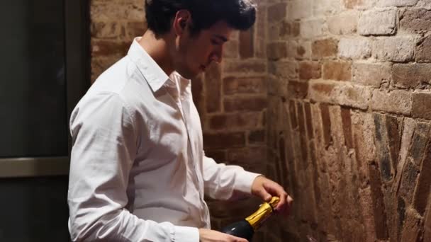 Genç Çekici Adam Şampanya Şişesini Açıyor Mantarı Çıkarıyor Zarif Beyaz — Stok video