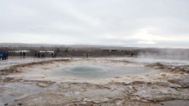 Geyser erupting in Iceland, producing big splash of hot water and steam