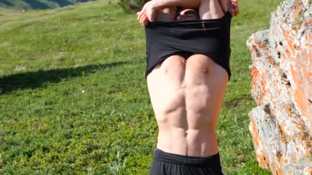 肌肉的年轻英俊男子脱衣服 脱掉白色的 露出赤裸翻录的躯干和胸部 Abs 手臂上的肌肉 — 图库视频影像