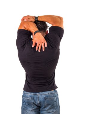 Handsome muscular man stretching arm and shoulder, isolated on white, wearing black t-shirt and jeans