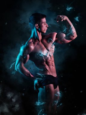 Stüdyoda siyah arka planda dramatik ışıklandırmayla çekilen kaslı genç erkek vücut geliştirici.