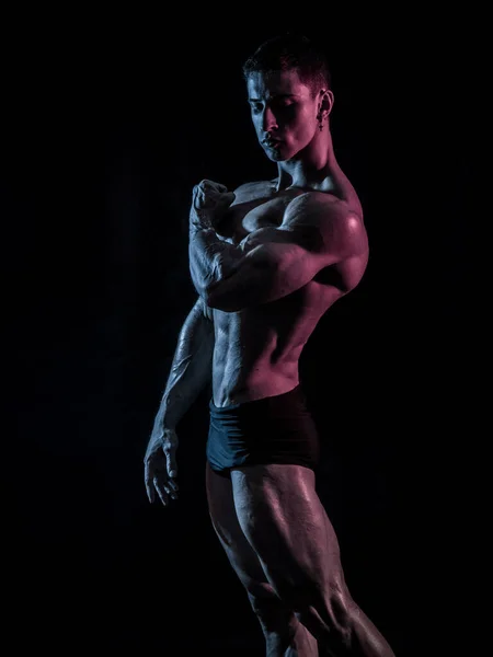 Bonito Jovem Fisiculturista Fazendo Pose Musculação Clássica Olhando Para Longe — Fotografia de Stock