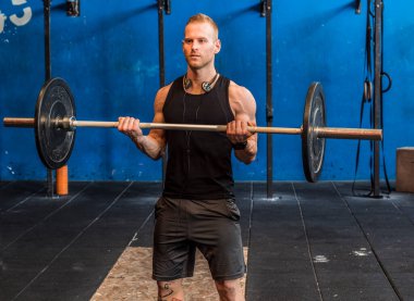 Silah barbell ile spor salonunda egzersiz kas yakışıklı genç.