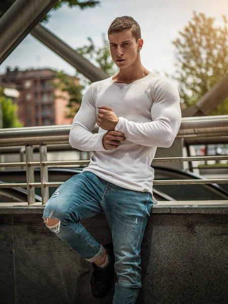 都市背景下身穿白衬衫和牛仔裤的肌肉发达的年轻人 — 图库照片
