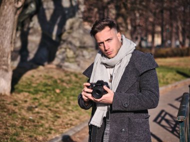 Yakışıklı genç erkek fotoğraf çekimi fotoğraf ile profesyonel fotoğraf makinesi, Şehir Parkı açık