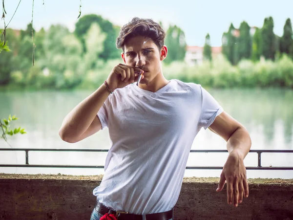 Şehir Ortamında Sigara Içen Yakışıklı Genç Adam Kameraya Bakıyor — Stok fotoğraf