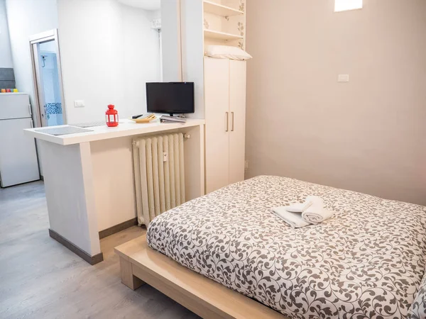コンテンポラリーなアパートメントで快適な柔らかいベッドと椅子が備わる小さな居心地の良い寝室のインテリア — ストック写真
