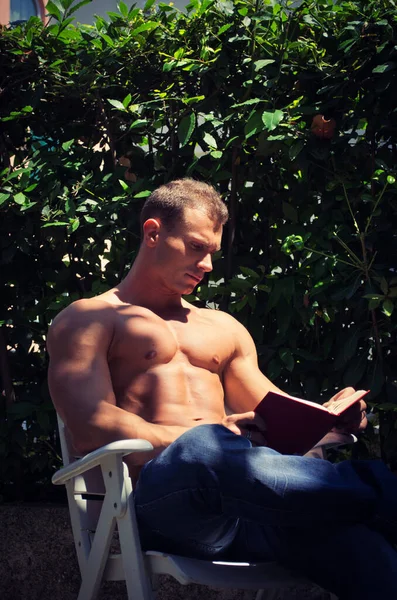 Красивый Мускулистый Молодой Человек Рубашки Читает Книгу Снаружи Показывая Мускулистые — стоковое фото