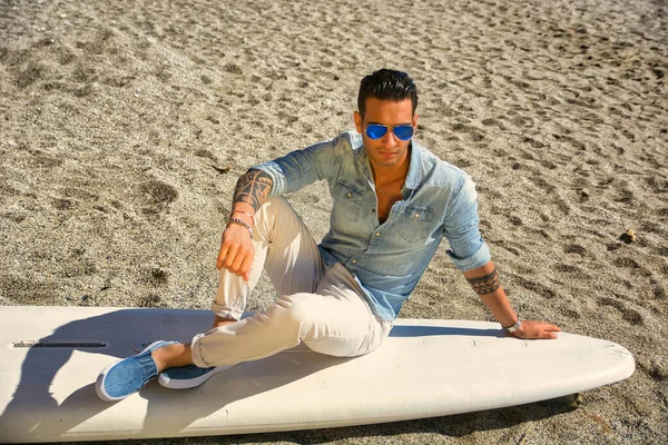Stylish Handsome Young Man Mirrored Sunglasses Sitting Surfboard Beach Sunlight — Stock Photo, Image
