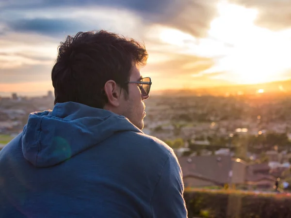 Güneş Gözlüklü Mavi Kapüşonlu Bir Adam Şehrin Üzerinde Parlak Turuncu — Stok fotoğraf