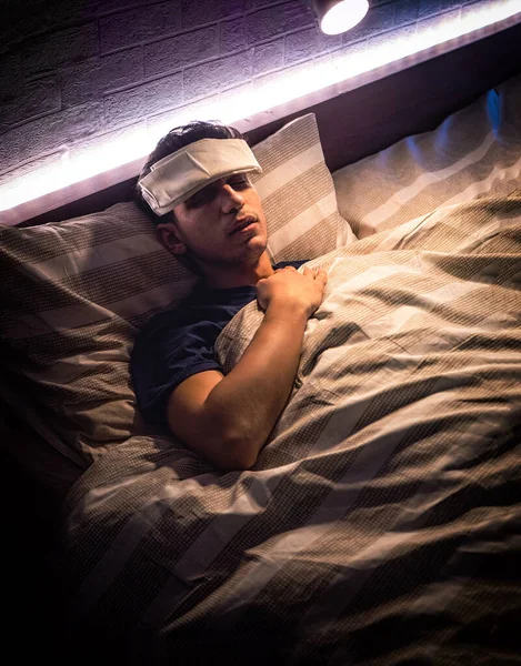 目を閉じて額に湿った布で インフルエンザや発熱とベッドの中で若いハンサムな病気や不健康な男 — ストック写真