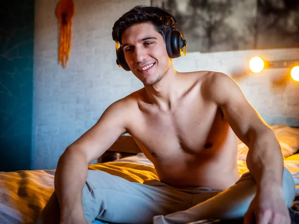 Приваблива Молода Людина Використовує Навушники Лежачи Ліжку Слухаючи Музику Добре — стокове фото