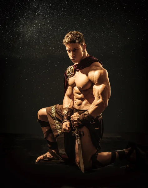 Handsome Muscular Young Man Posing Kneeling Roman Spartan Gladiator Costume — Stock Photo, Image